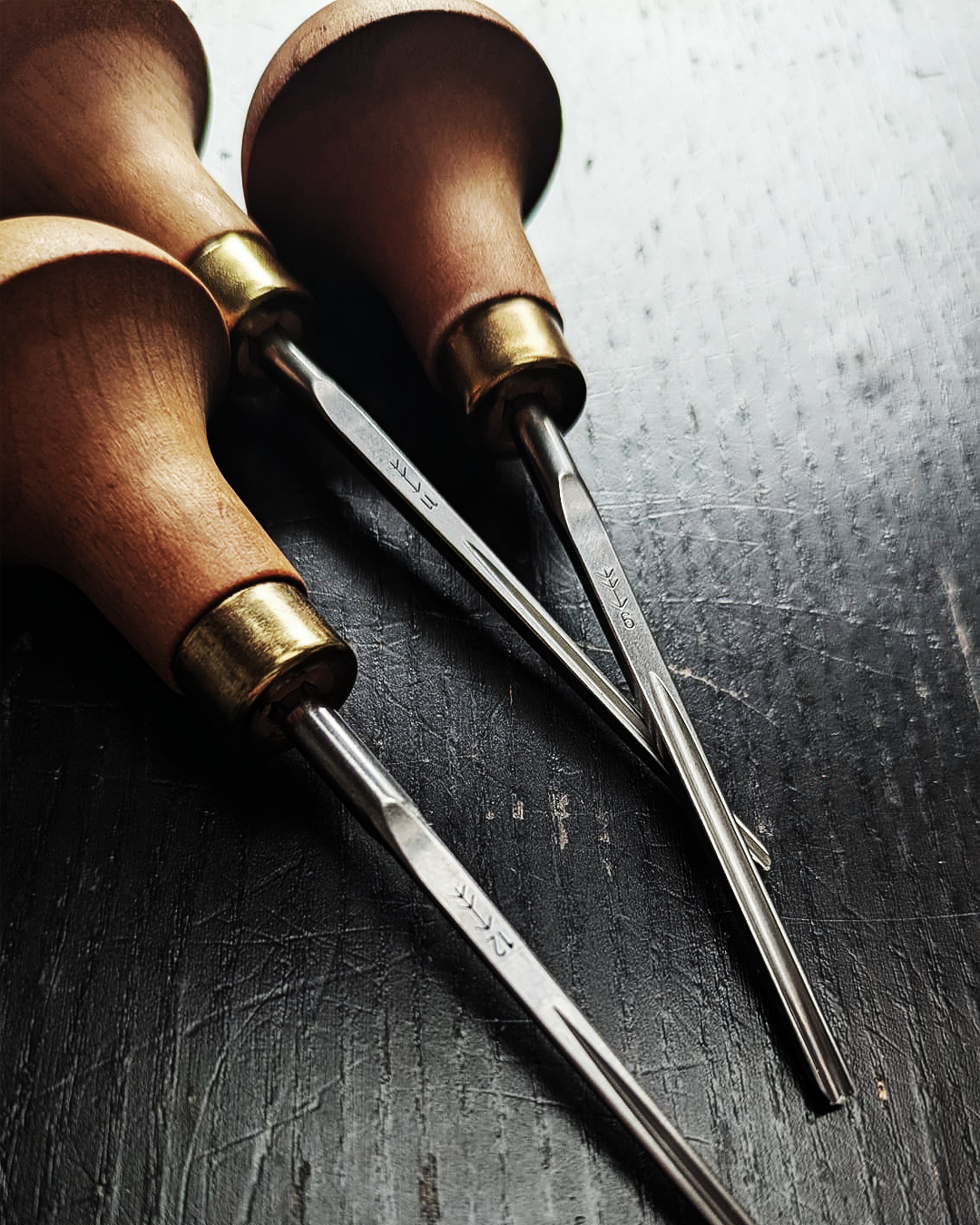 Set of linocut gouges on a wooden table, traditional tools for handmade prints.