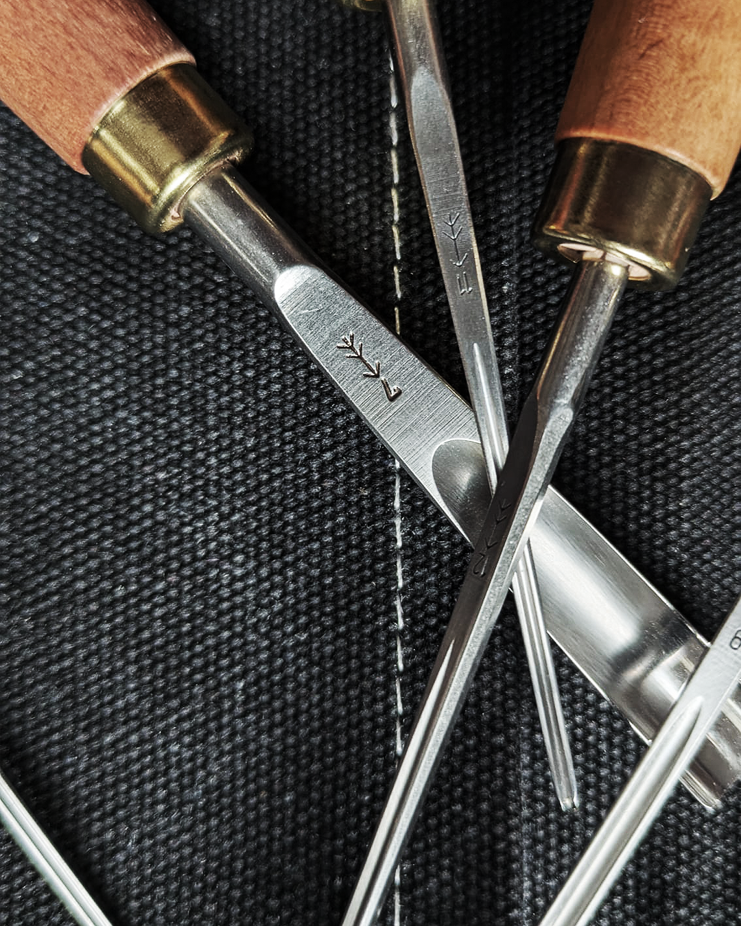 Close-up of linocut gouges with steel details, carving tools for artisanal prints.